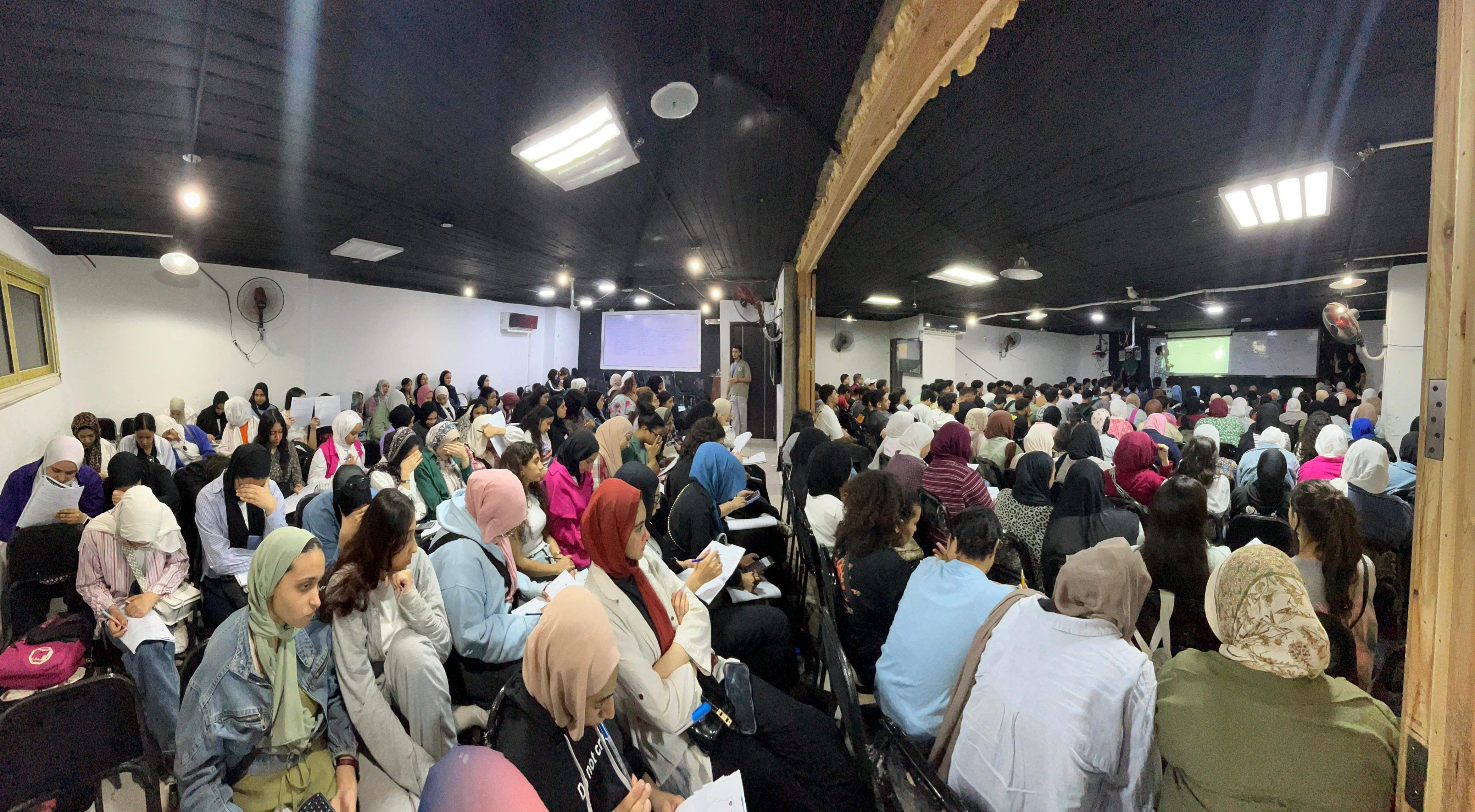 Classroom view of Mr Alayman Hassan teaching with screens